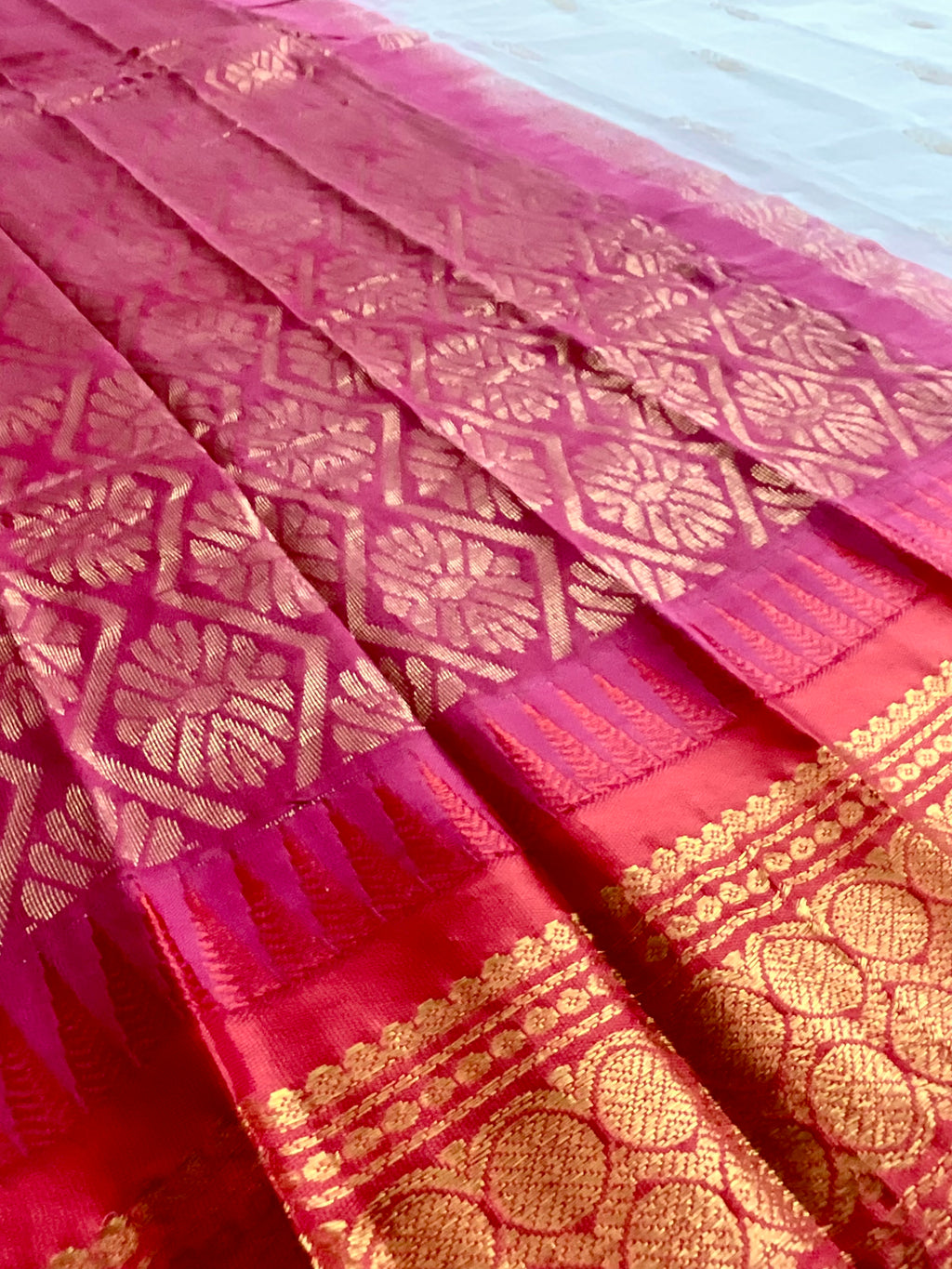 Draped white Gadwal silk saree with reddish-pink border