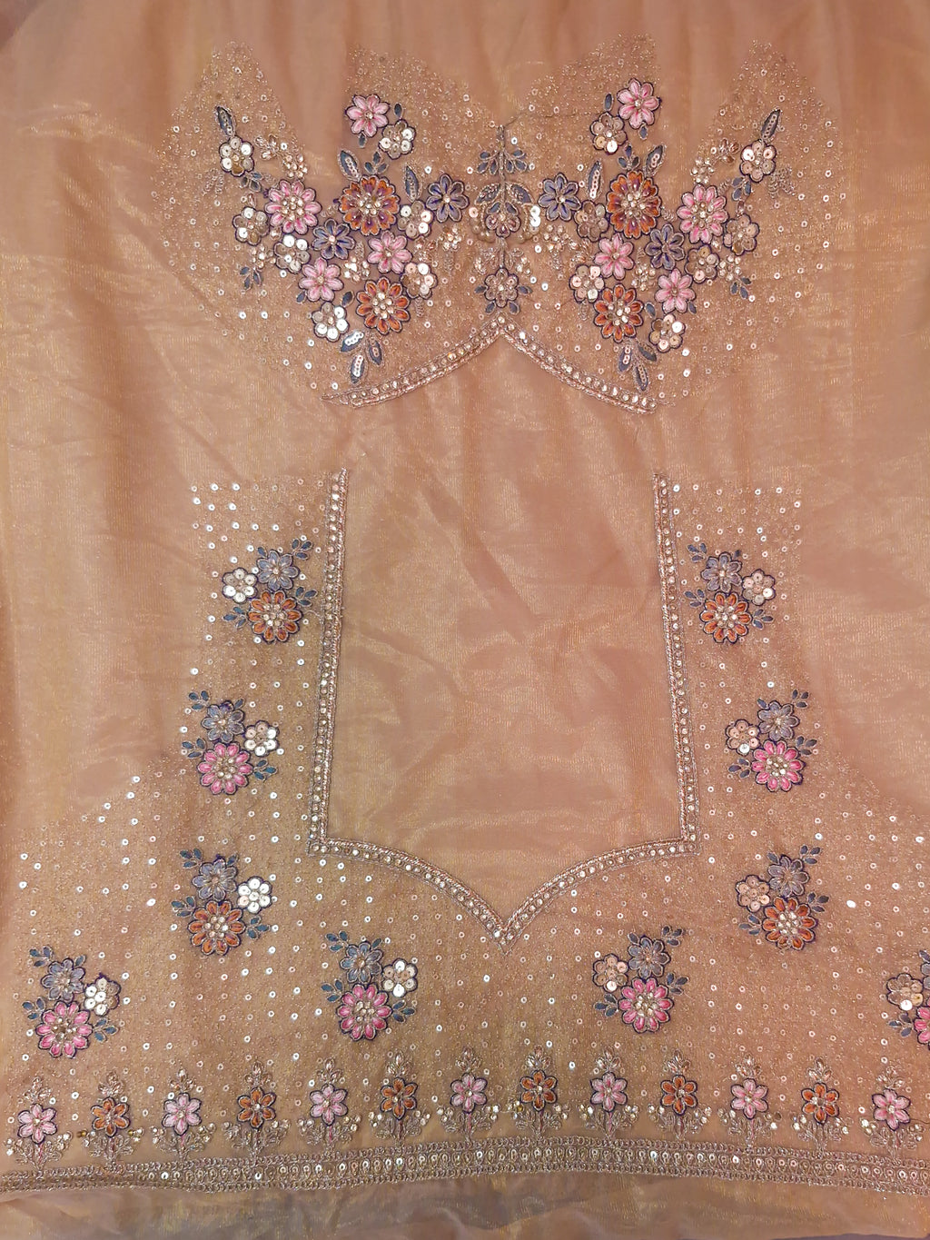 A peach-colored embroidered fabric panel, likely part of a traditional ethnic outfit, featuring intricate floral embroidery in pink, orange, and blue with silver mirror work and bead borders.
