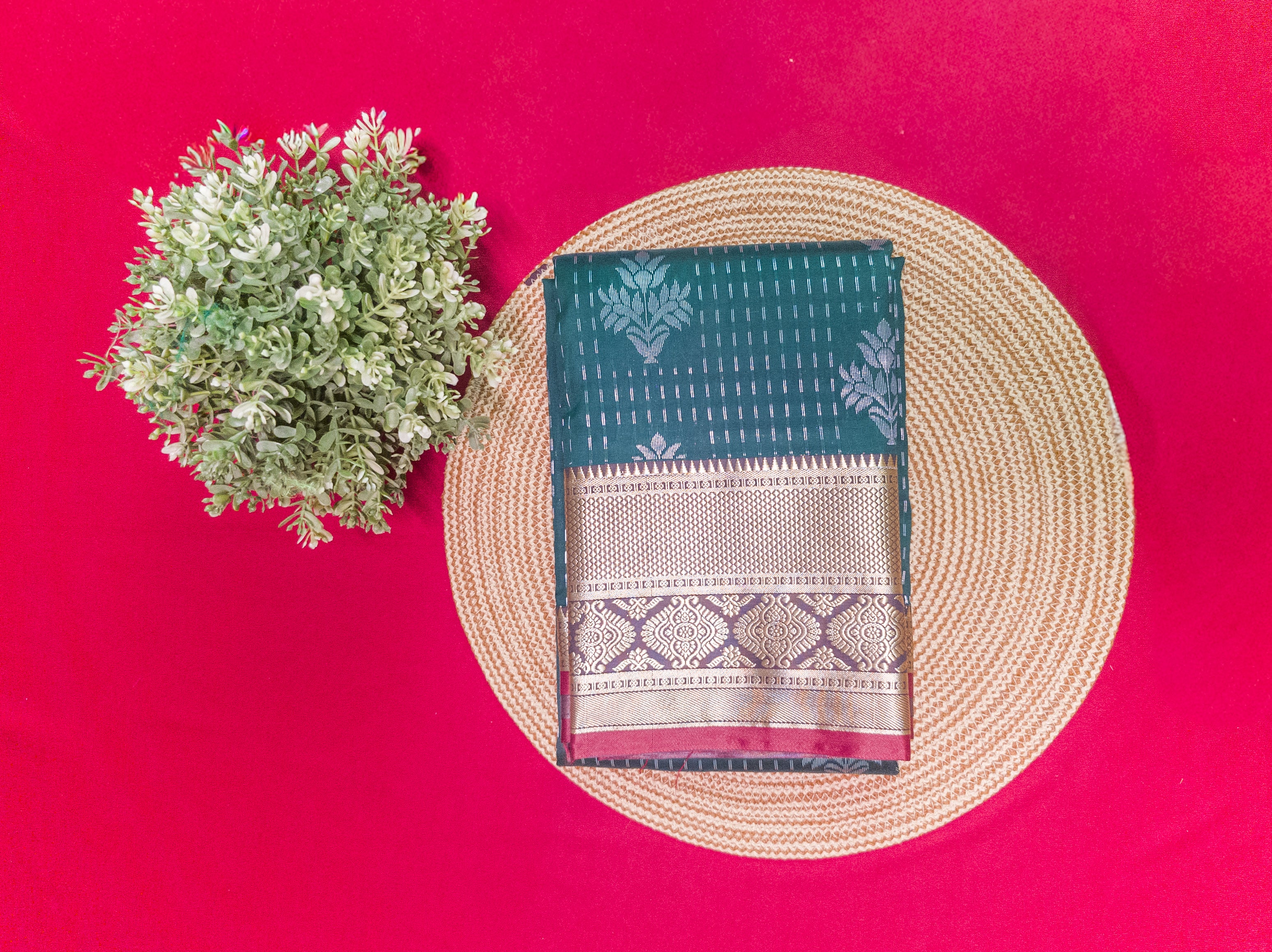 Teal fabric with white patterns on a woven mat against a red background